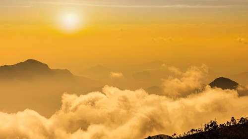 Panorama of mountains in clouds on sunset