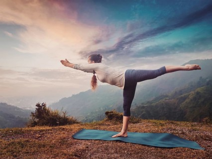 Yoga outdoors, sporty fit woman doing Ashtanga Vinyasa Yoga asana Virabhadrasana 3 Warrior pose