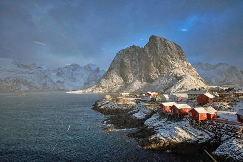 Hamnoy fishing village on Lofoten Islands, Norway with red rorbu houses. With falling snow blizzard
