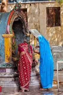 MADURAI, INDIA, FEBRUARY 16, 2013: Unidentified Indian women worship Hindu god Ganesh in famous