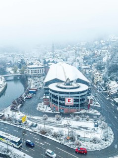 Aerial view of Kaufland, snow-covered shopping centre on a city street from a bird's eye view,