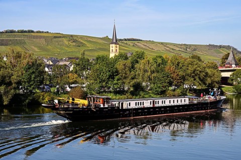 Barge travelling on the Moselle past the village of Trittenheim, Rhineland-Palatinate