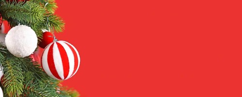 Christmas banner with striped red and white bauble on tree branch