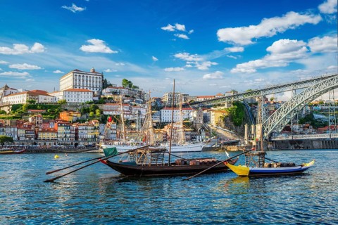 View of Porto city and Douro river with traditional boats with port wine barrels and sailing ship
