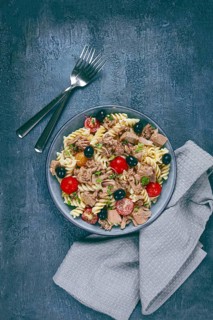 Fusilli pasta salad with canned tuna, cherry tomatoes and olives, parmesan, microgreens, homemade,