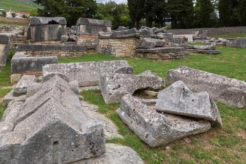Close-up of old large and heavy broken pieces of cut and carved grey granite, stone and wall