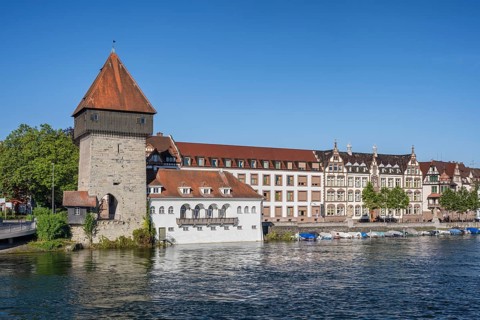 View from the old Rhine bridge to the banks of the Rhine with the historic Rhine gate tower in the