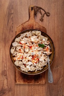 The dish features a generous serving of Turkish dumplings topped with velvety yogurt and a drizzle