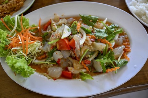Spicy jellyfish salad with celery, onions, chilli, lime and fresh coriander leaves in a street