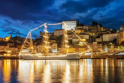View of Porto city and Douro river with sailing ship from famous tourist viewpoint Marginal de Gaia