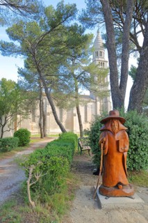 Wooden pilgrim in front of the baroque church Notre-Dame de Beauregard, wood carving, wooden