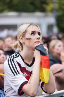 A woman watches the football match in the fan zone at the Brandenburg Tor during the quarter-final