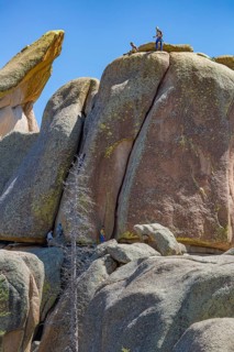 Men rock climbing on a large granite boulder in the Vedauwoo Recreation Area of Medicine Bow