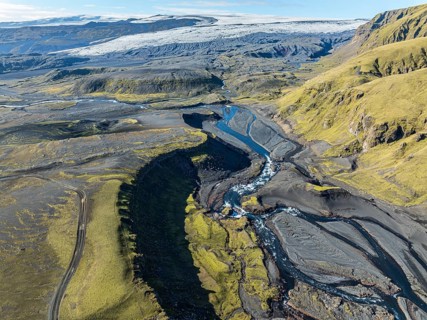 River along road F232 Öldufellsleid, slopes of Mt. Öldufell, moss-covered hill in black lava sand,