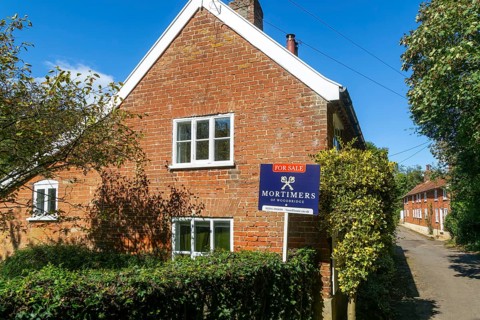 Mortimers estate agents For Sale sign outside residential home, Shottisham, Suffolk, England, UK