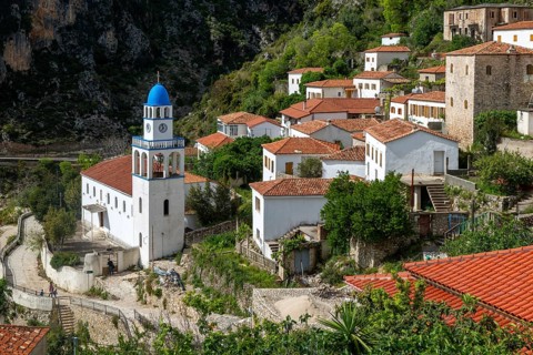 View over houses and rooftops to Greek Orthodox Church of Saint Spyridon, village of Dhermi,