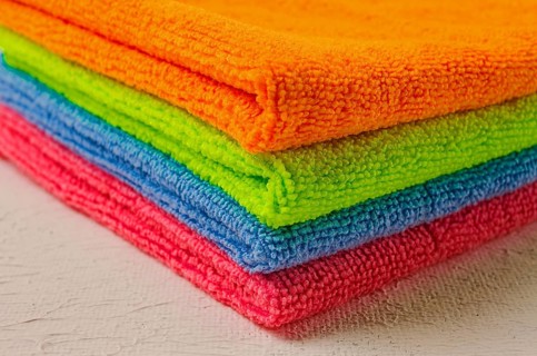 A stack of colored cloth, microfiber, for cleaning the house, on a white table, horizontal, no