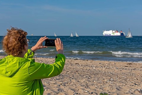 Older woman taking photos of boats, sailing boats, ferry, smartphone, Kieler Woche, Falckensteiner