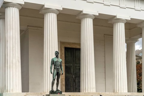 Statue of a young athlete and the Theseus Temple in the Volksgarten Vienna, Austria, Europe