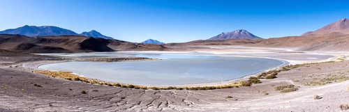 Panorama of Laguna Honda, lined with a few bushes, lagoon route, San Pedro de Quemes, Departamento