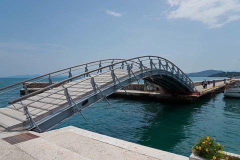 Arched bridge over the water with flower arrangement, surrounded by harbour and sky, Arched bridge,