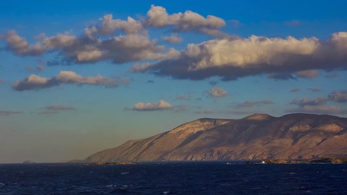 Vast seascape with mountains in the background and a sky full of clouds in daylight, Kassos Island,