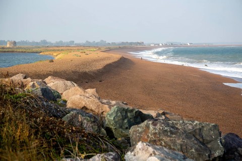 North Sea coastline view of rock armour and beach bar north to Shingle Street, East Lane, Bawdsey,