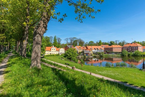 Old town of Nyborg, moat around the medieval town, houses at the castle wall, water reflection,