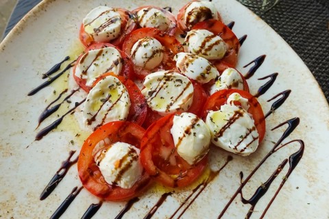 Italian cuisine, Insalata Caprese, vine tomatoes, buffalo mozza arranged on a plate, balsamic