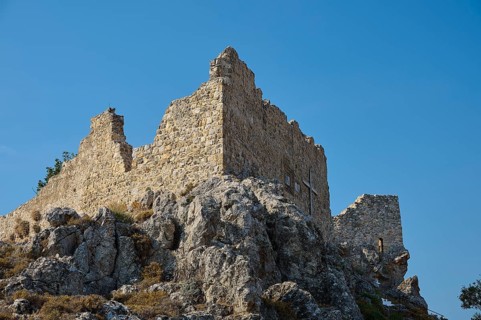 Stony ruins of an ancient tower on a rock under a clear blue sky, St John's Castle, Archengelos