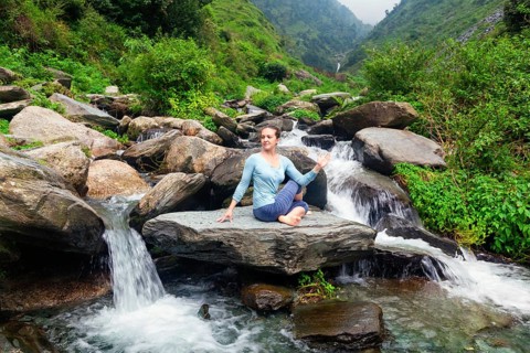 Yoga exercise outdoors, woman doing Ardha matsyendrasanaasana asana, half spinal twist pose at