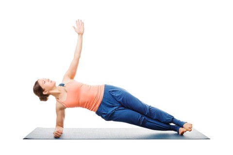 Hatha yoga, sporty fit woman doing yoga asana Vasisthasana, side plank pose modification for wrists