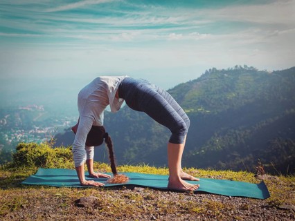 Yoga outdoors, young sporty fit woman doing Ashtanga Vinyasa Yoga asana Urdhva Dhanurasana, upward