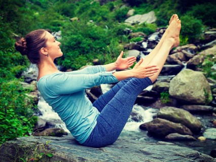 Yoga outdoors, young sporty fit woman doing Ashtanga Vinyasa Yoga asana Navasana, boat pose, in