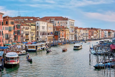VENICE, ITALY, JUNE 27, 2018: Grand Canal with boats, vaporetto and gondolas on sunset from Rialto