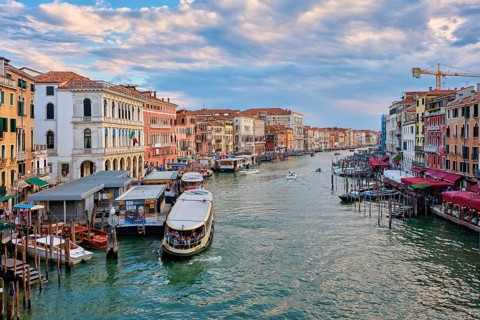 VENICE, ITALY, JUNE 27, 2018: Grand Canal with boats, vaporetto and gondolas on sunset from Rialto
