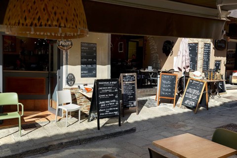 Many signs with Corsican specialities in front of a restaurant, old town of L'Île-Rousse, Ile