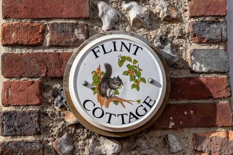 Painted tile on a house wall, Alfriston, East Sussex, England, Great Britain
