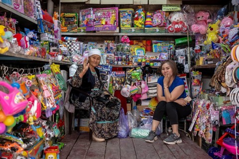 Two woman selling toys and magazines, market stall at the Osh Bazaar, Bishkek, Kyrgyzstan, Asia