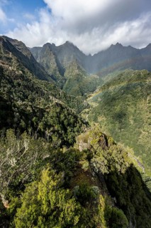 Densely overgrown steep mountains with rainbow, green mountain landscape, view from Miradouro dos
