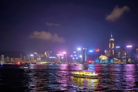 Hong Kong skyline cityscape downtown skyscrapers over Victoria Harbour in the evening illuminated