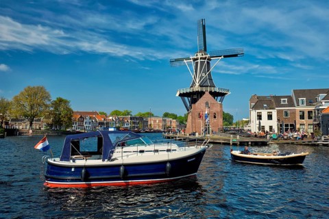 HAARLEM, NETHERLANDS, MAY 6, 2017: Harlem cityscape with windmill De Adriaan on Spaarne river.