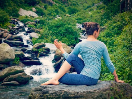 Yoga exercise outdoors, woman doing Ardha matsyendrasana asana, half spinal twist pose at tropical