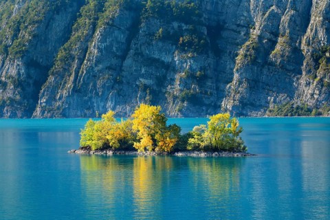 Small chive island in the turquoise waters of Lake Walen, Canton St. Gallen, Switzerland, Europe