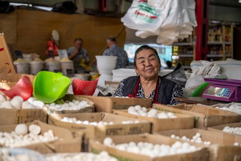 Traditional woman selling food, market stall at Osh Bazaar, Bishkek, Kyrgyzstan, Asia