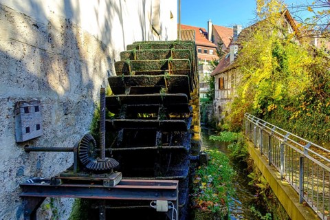 Symbolic image of historical mill wheel and concept of water energy and sustainability, here using