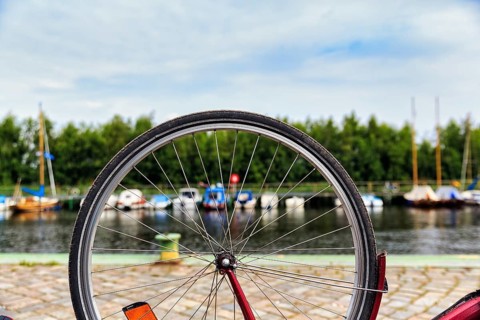 View through the spokes of a bicycle at boats on the river, symbolic image, repairing a bicycle,