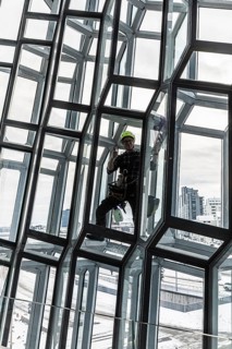 Window cleaners cleaning the glass facade of the Harpa Concert Hall and Congress Centre, interior