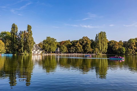 Beer garden and pedal boats at Kleinhesseloher See in the English Garden, Munich, Bavaria, Germany,