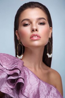 Beautiful fresh girl with classic make-up, smooth hair in a purple dress. Beauty face. Photo taken